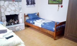 卡兰巴卡Argiris Old City House 1的一间卧室配有一张床和一个壁炉