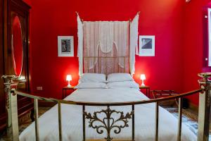 佩奥拉Monreal Boutique Townhouse - R024RM4的一间卧室配有一张红色墙壁的床和两盏灯。