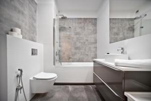 华沙zoliborz的浴室配有卫生间、盥洗盆和浴缸。