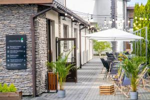 克拉科夫JJ Sport Concept Hotel的户外庭院配有遮阳伞和桌椅。