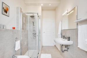 帕尔马AriediParma Appartamenti的带淋浴和盥洗盆的白色浴室