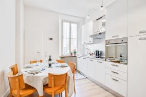 帕尔马AriediParma Appartamenti的白色的厨房配有桌椅