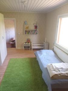 伊萨尔米Laukkumäki farm的一间卧室配有床和绿色地毯