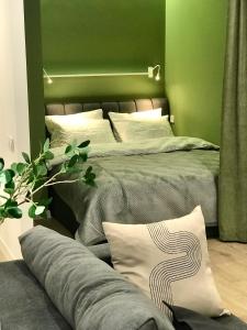 赫梅利尼茨基Modern Studio City Center дуже затишно!的一间卧室配有一张带绿色墙壁的床