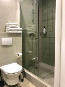 赫梅利尼茨基Modern Studio City Center дуже затишно!的带淋浴、卫生间和毛巾的浴室