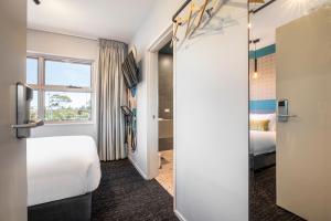 墨尔本Royal Hotel by Nightcap Social的酒店客房设有床和窗户。
