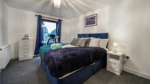 斯劳LiveStay-New Private Apartment Building Minutes From Heathrow的一间卧室设有蓝色的床和窗户。