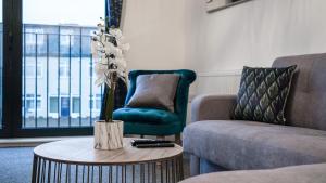 斯劳LiveStay-New Private Apartment Building Minutes From Heathrow的客厅配有沙发和带花瓶的桌子