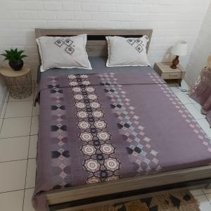 MamoudzouLÃCAZÈRĂ Sãfãrì的一张带紫色毯子和枕头的床