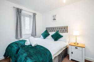 巴塞尔顿Stunning 3BR house in Basildon的一间卧室配有一张带绿毯的大床