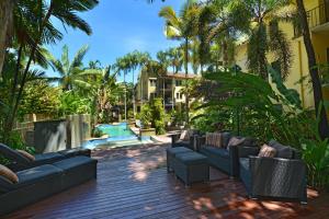 道格拉斯港礁石俱乐部度假酒店的带沙发的庭院、游泳池和棕榈树