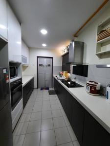 普特拉贾亚HillTree Homestay Putrajaya的一间铺有白色瓷砖地板的厨房和一间大厨房