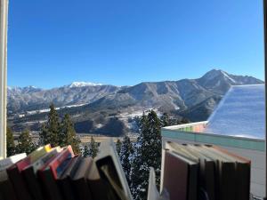 南鱼沼市Ishiuchi Ski Center的阳台享有山景,配有书籍