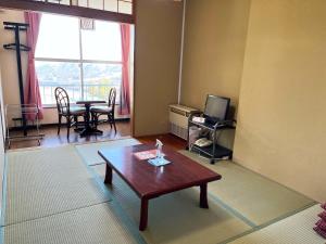 南鱼沼市Ishiuchi Ski Center的客厅配有咖啡桌和电视