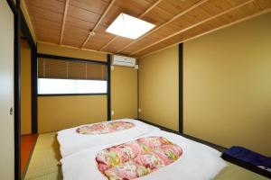 京都林恩伏见稻荷度假屋的天花板客房内的两张床