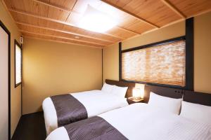 京都林恩伏见稻荷度假屋的带2扇窗户的客房内的2张床