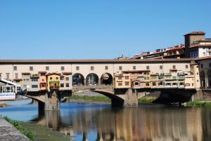 佛罗伦萨Residenza Ponte Vecchio Firenze的一条河上的桥梁,人们在河上走