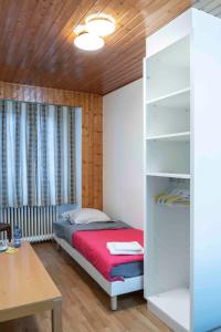 拉绍德封Hôtel du Cheval-Blanc的一间小卧室,配有一张床和一张书桌