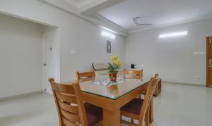 钦奈Treebo Rithikha Inn Elite Chennai Trade Centre的一间带桌椅的用餐室