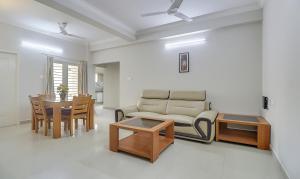 钦奈Treebo Trend Rithikha Inn Elite Chennai Trade Centre的客厅配有沙发和桌子