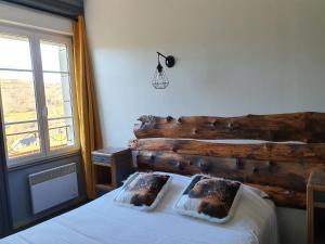 CheyladeGrand Hotel de la Vallée的一间卧室配有木制床头板,床上配有两个枕头