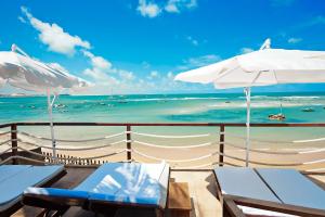 皮帕马林精品酒店的海滩上设有椅子和遮阳伞,还有大海