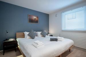富良野ArtHouse by H2 Life的一间卧室配有一张大床和毛巾