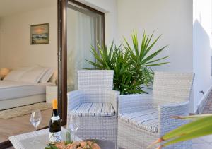 乌马格Apartments Villa Rosi的一张桌子、两把椅子和一瓶葡萄酒