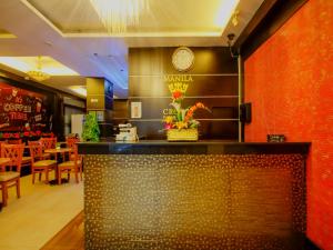 马尼拉Super OYO 838 Manila Crown Palace Hotel的墙上有时钟的柜台的餐厅