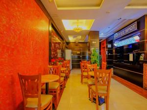 马尼拉Super OYO 838 Manila Crown Palace Hotel的餐厅内带桌椅的用餐室