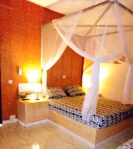 尼亚加乐查玛玛酒店 的一间卧室配有一张带天蓬的床