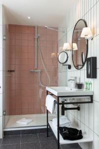 巴黎巴斯提尔斯佩利亚酒店的带淋浴、盥洗盆和镜子的浴室