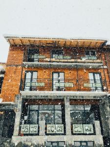 梅斯蒂亚Hotel Ailama Mestia的一座砖砌的建筑,雪落在里面