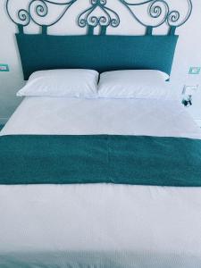 蒙泰迪普罗奇达Lavinum的一张带绿色床头板和白色床单的床
