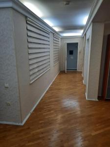 巴库Compleks Hostel of Nizami street的一间空房间,走廊上铺有木地板