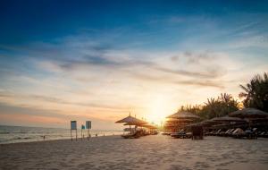 美奈翠竹村庄海滩水疗度假酒店的海滩上的日落,太阳伞和海洋