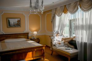 圣彼得堡艾米瑞达格兰德酒店的坐在卧室椅子上的女人