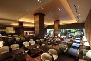 仙台仙台大都会酒店的一间带桌椅的餐厅和一间酒吧