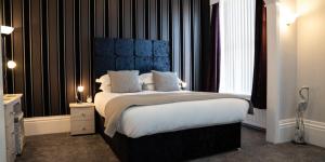 布莱克浦Fox lodge的一间卧室配有一张大床和蓝色床头板