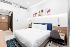 迪拜Resivation Hotel的卧室配有一张白色大床和一把椅子