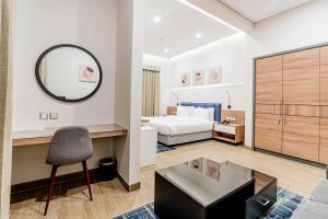 迪拜Resivation Hotel的一间卧室配有一张床、一张书桌和一面镜子