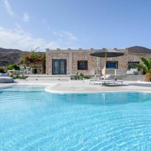 FoinikiáVilla Beltramo Santorini 2 bedroom private pool villa的房屋前带遮阳伞的大型游泳池