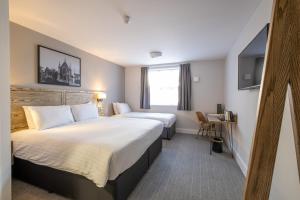 切普斯托两江马斯顿旅馆的酒店客房设有两张床和窗户。