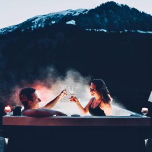 昆塔尔Historisches Hotel Bären的男人和女人在浴缸里喝杯酒