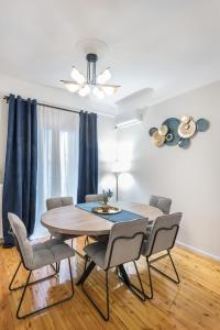 塞萨洛尼基Porto Sea View Apartments - Kypriou的一间带木桌和椅子的用餐室