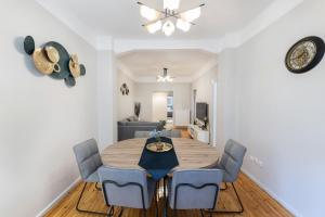 塞萨洛尼基Porto Sea View Apartments - Kypriou的一间带桌子和蓝色椅子的用餐室