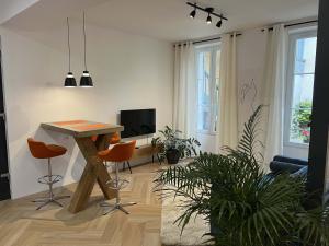 茹瓦尼Bel appartement au centre du vieux Joigny的客厅配有木桌和椅子
