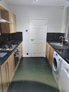 Longley24 Dryden Road - Beautiful 2 bed的厨房设有白色的门、洗衣机和水槽