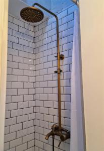 里斯本Janelas Verdes - Peaceful Views的一间带淋浴的浴室,铺有白色的瓷砖墙