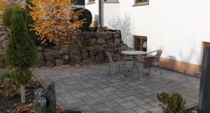 伦山前比绍夫斯海姆Ferienwohnung Gutwin的一个带桌椅和石墙的庭院